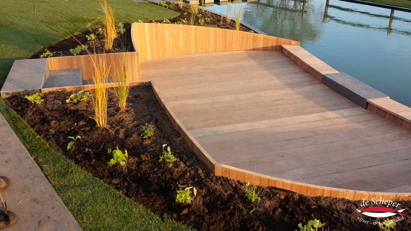 Natuurlijke Integratie in Tuin Zwemvijver harmonieus geïntegreerd in natuurlijke omgeving, met waterloop, holle ruimte en plantenfilter.
